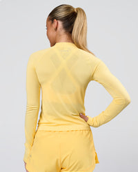 Woman wearing AeroFLX+ Long Sleeve Half Zip - Lemon/Lemon | Model:Issy | Size:XS | Thumbnail Index: 2