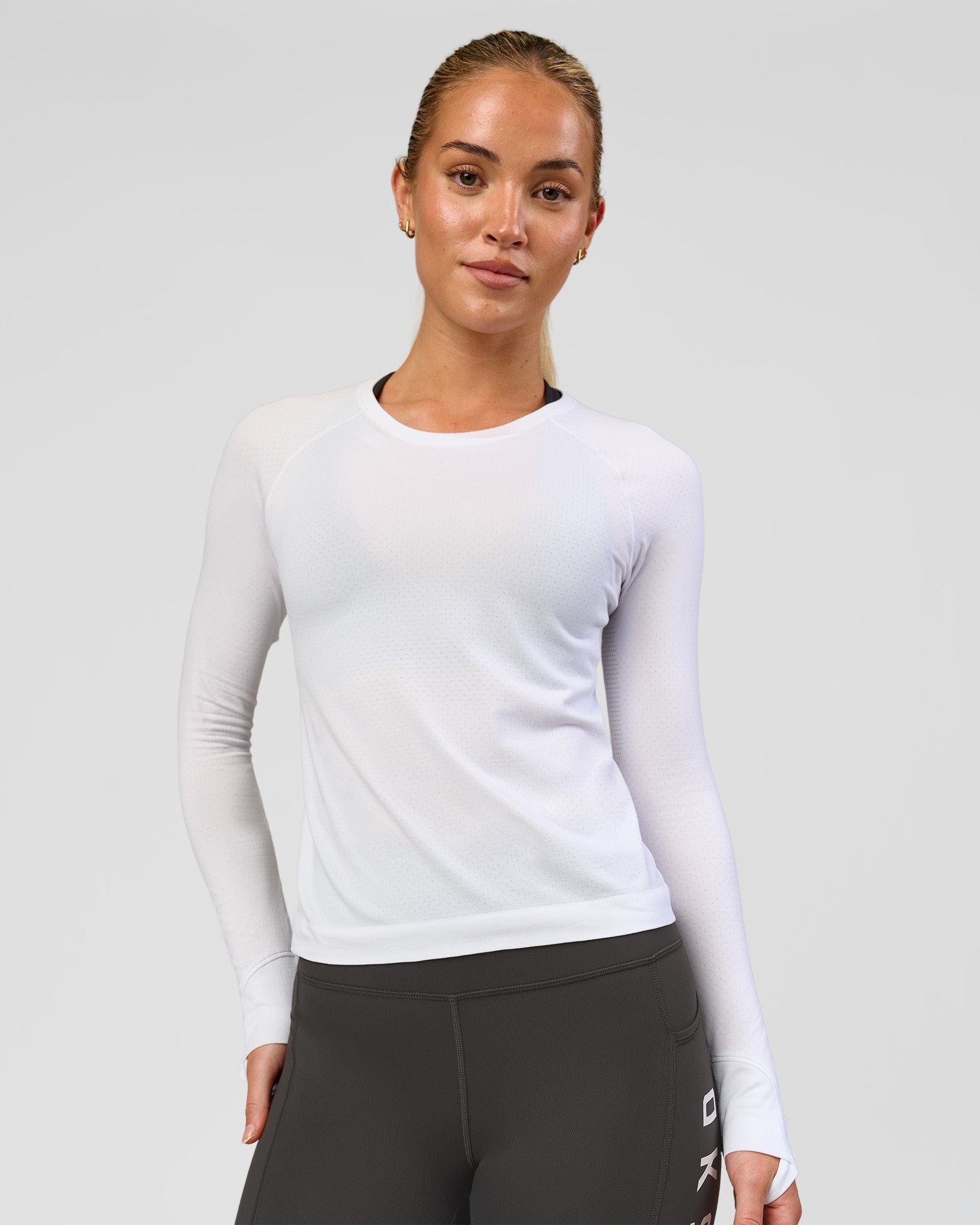 Woman wearing AeroFLX+ Seamless Long Sleeve Tee - White/White | Model:Issy | Size:XS