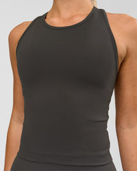 Woman wearing Flow Performance Tank 2.0 - Onyx | Model:Issy | Size:XS | Thumbnail Index: 1