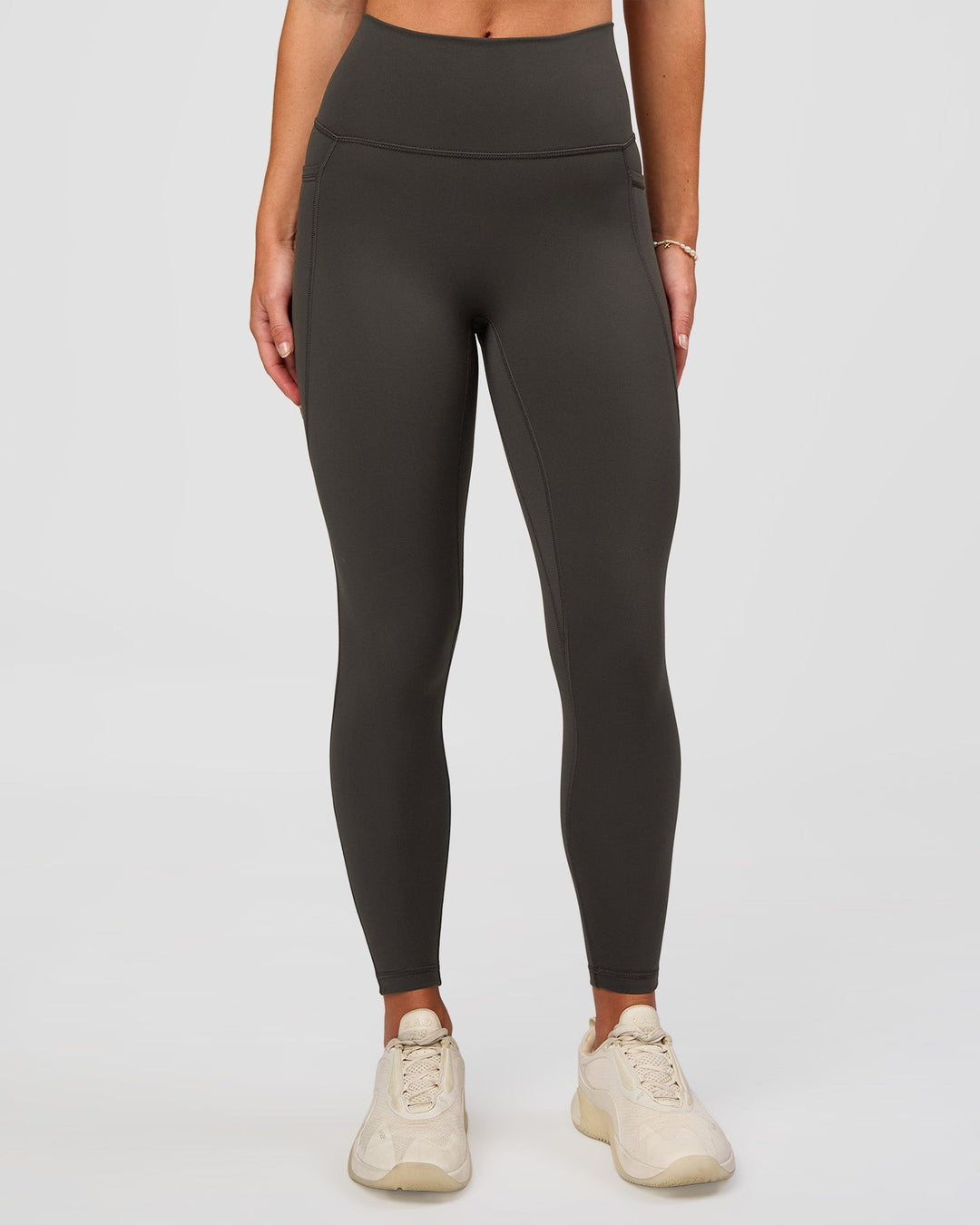 Woman wearing Fusion Ultra High-Rise 7/8 Legging Pockets - Onyx | Model:Issy | Size:XS - view 1