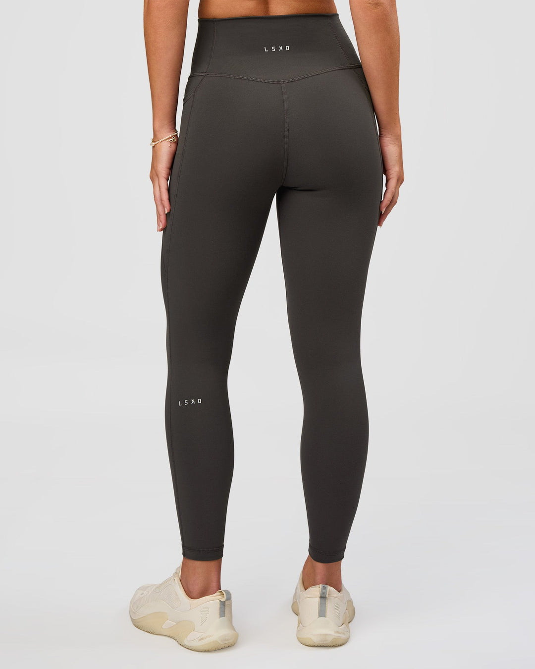 Woman wearing Fusion Ultra High-Rise 7/8 Legging Pockets - Onyx | Model:Issy | Size:XS - view 3