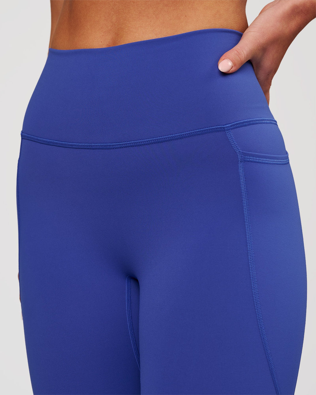 Woman wearing Fusion V-Contour Ultra High-Rise 7/8 Legging Pockets - Power Cobalt | Model:Issy | Size:XS - view 4