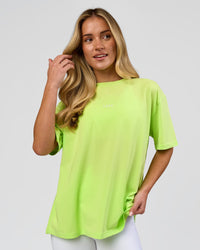 Woman wearing Go-To FLXCotton Oversized Tee - Lime Glo-White | Model:Issy | Size:XS | Thumbnail Index: 0