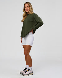 Woman wearing Go-To Long Sleeve FLXCotton Oversized Tee - Pure Olive-White | Model:Issy | Size:XS | Thumbnail Index: 4
