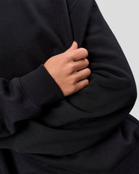 Woman wearing Go-To Oversized Sweater - Black | Model:Issy | Size:XS