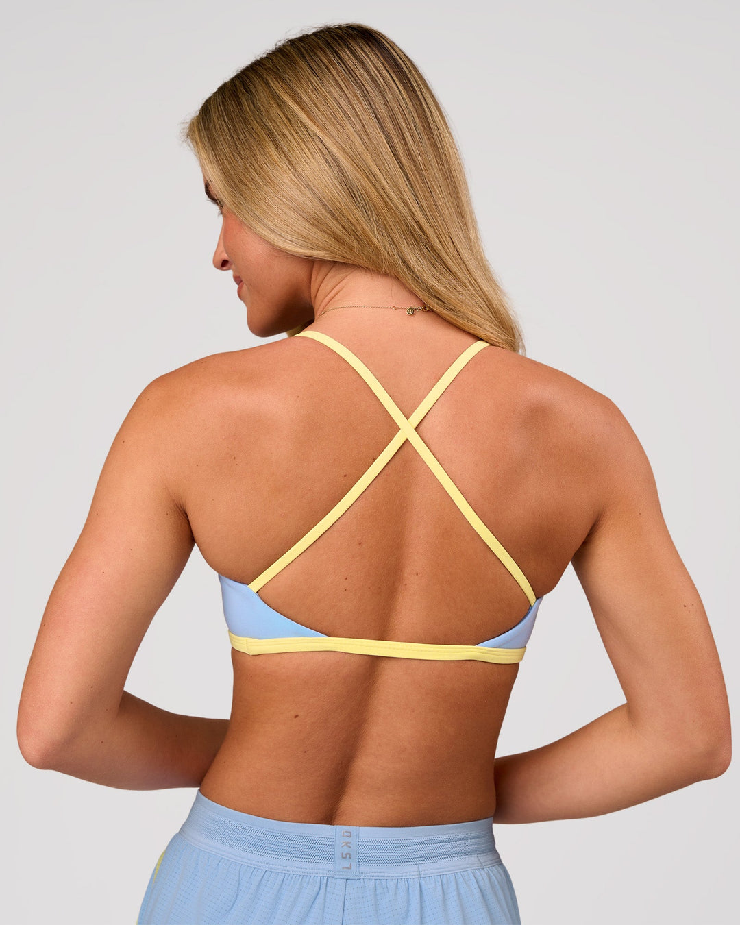 Woman wearing Liberate Sports Bra - Open Air-Lemon | Model:Issy | Size:XS - view 3