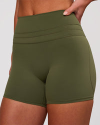 Woman wearing Luxe V-Contour High-Rise 4" Short - Pure Olive | Model:Issy | Size:XS | Thumbnail Index: 1