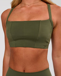 Woman wearing Momentum Corset Sports Bra - Pure Olive | Model:Issy | Size:XS | Thumbnail Index: 0