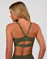 Woman wearing Momentum Corset Sports Bra - Pure Olive | Model:Issy | Size:XS | Thumbnail Index: 3