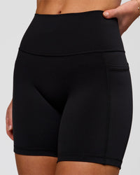 Woman wearing O.G. Fusion Ultra High-Rise 6" Short Pockets - Black | Model:Issy | Size:XS | Thumbnail Index: 1