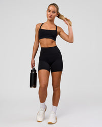 Woman wearing O.G. Fusion Ultra High-Rise 6" Short Pockets - Black | Model:Issy | Size:XS | Thumbnail Index: 3