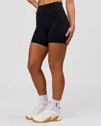 Woman wearing O.G. Fusion Ultra High-Rise 6" Short Pockets - Black | Model:Issy | Size:XS | Thumbnail Index: 11