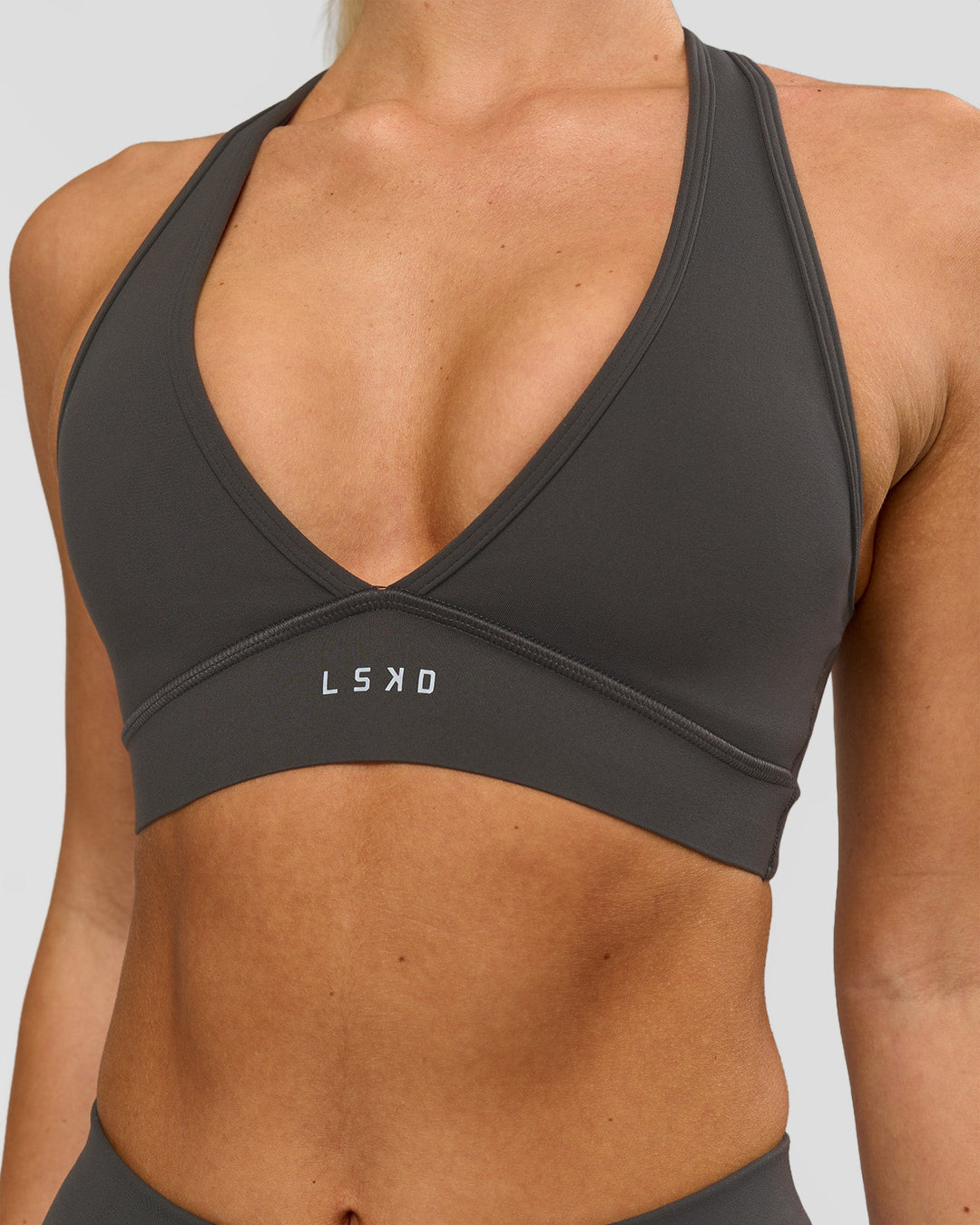 Woman wearing Stamina Sports Bra - Onyx | Model:Issy | Size:XS - view 1