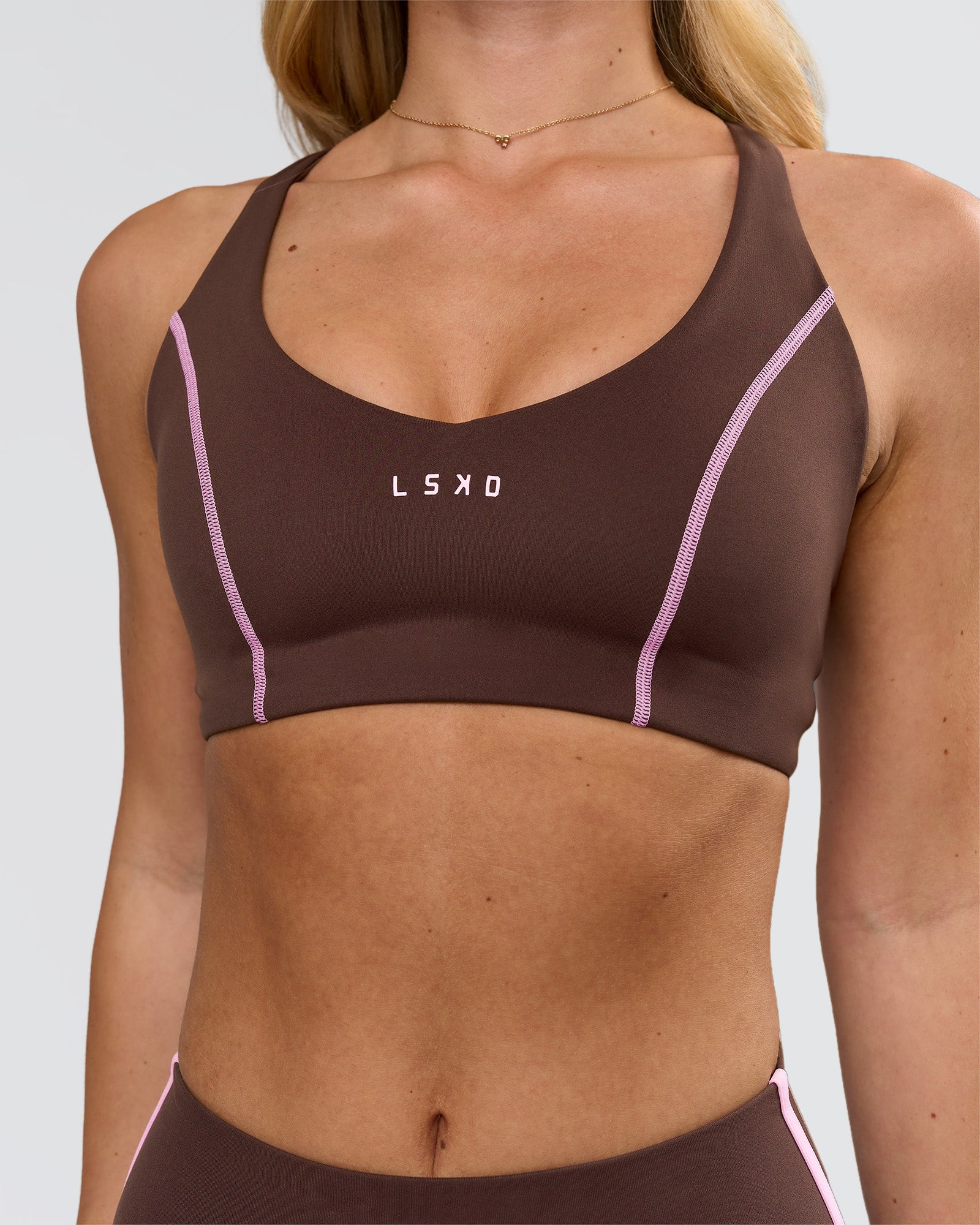 Woman wearing Stellar Sports Bra - Hot Chocolate-Pink Rose | Model:Issy | Size:XS