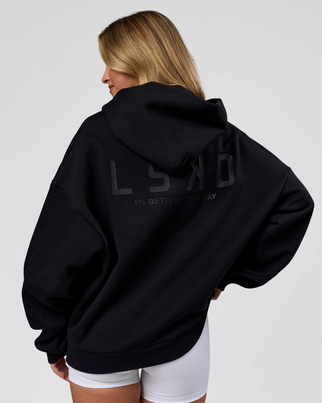 Woman wearing Tonal Legacy Boxy Hoodie - Black-Black | Model:Issy | Size:XS - view 3