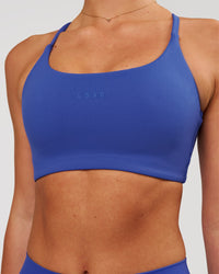Woman wearing Twist Sports Bra - Power Cobalt | Model:Issy | Size:XS | Thumbnail Index: 1