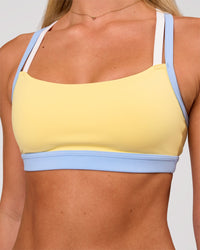 Woman wearing Velocity Sports Bra - Lemon-Open Air | Model:Issy | Size:XS | Thumbnail Index: 0