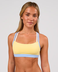 Woman wearing Velocity Sports Bra - Lemon-Open Air | Model:Issy | Size:XS | Thumbnail Index: 2