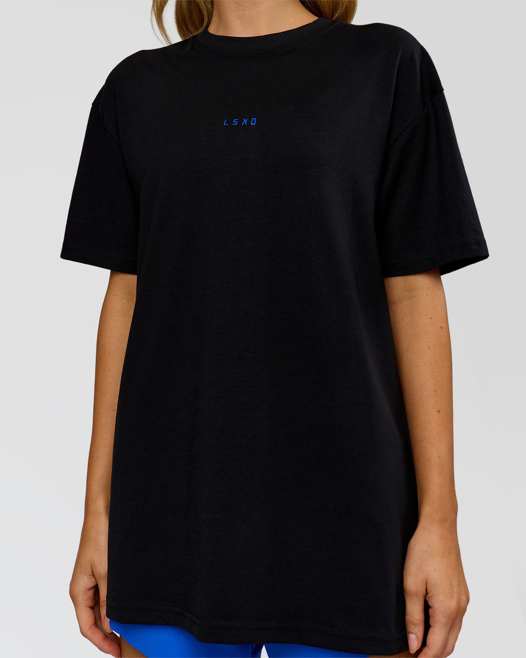 Woman wearing Run Club Elevate FLXCotton Oversized Tee - Black-Electric Indigo | Model:Leilani | Size:XS