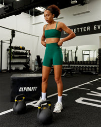 Woman wearing Fusion Ultra High-Rise 6" Short Pockets - Malachite | Model:Txai | Size:XS