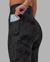 Woman wearing Fusion Ultra High-Rise 7/8 Legging Pockets - Black Tie-Dye | Model:Milly | Size:S