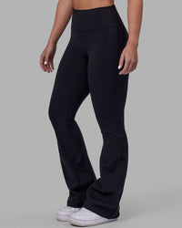 Woman wearing Fusion Ultra High-Rise Flared Petite Legging - Black| Model:Gracie | Size:S