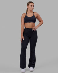 Woman wearing Fusion Ultra High-Rise Flared Petite Legging - Black| Model:Gracie | Size:S